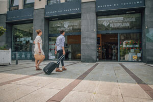 Image de 2 touristes entrant dans un office de tourisme